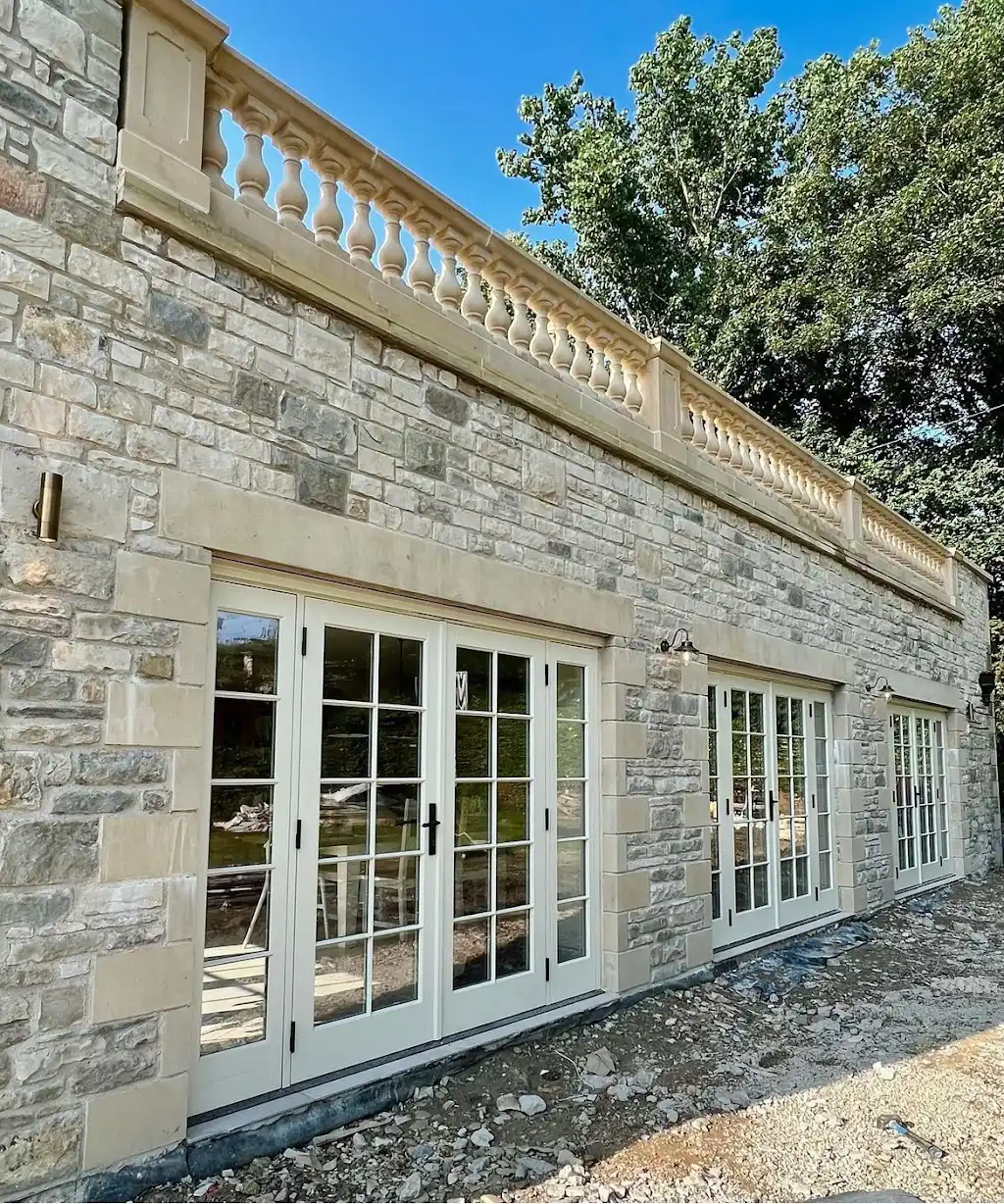 Stone exterior building work with doors and balustrade by Roman City Construction